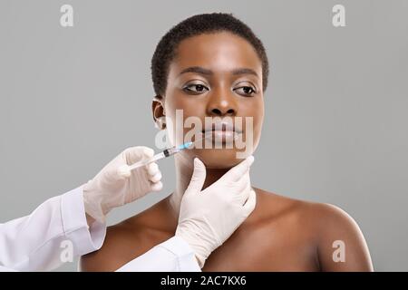 African american woman making lip augmentation procedure by doctor Stock Photo