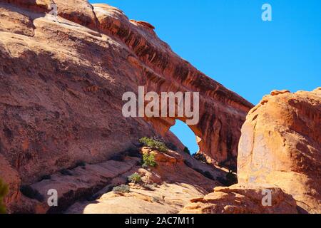 A large natural window in a huge sandstone wall creates the Partition Arch in Arches National Park. Stock Photo