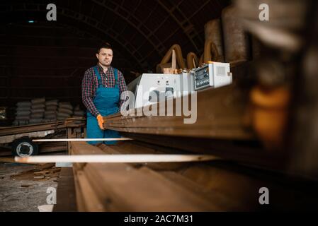 Carpenters in uniform holds stack of boards Stock Photo