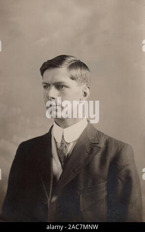 Vintage photographic postcard of a young man circa 1910. Stock Photo