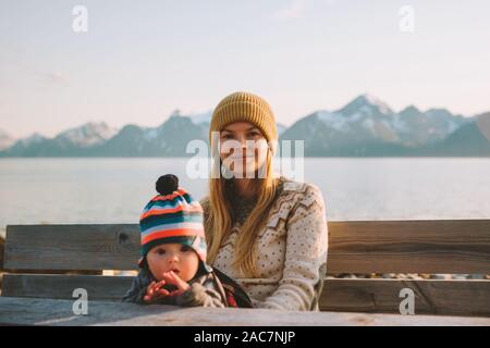 Mother traveling with baby in Norway relaxing  enjoying mountains view family vacation mom and child active healthy lifestyle outdoor Stock Photo