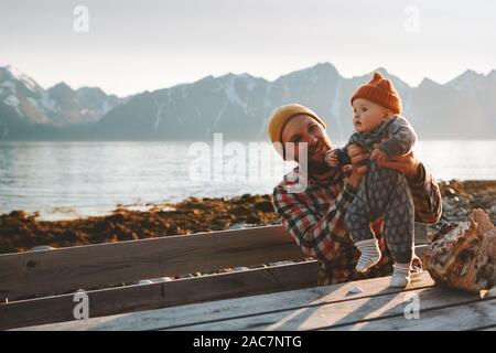 Father traveling with baby in Norway relaxing enjoying mountains view family vacation dad and child playing outdoors active healthy lifestyle Stock Photo