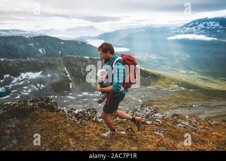 Father and baby hiking together travel family adventure with kids in mountains lifestyle outdoor vacation in Norway Stock Photo
