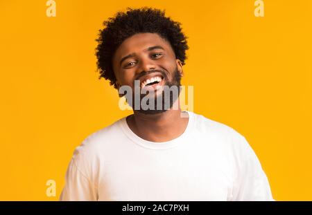 Portrait of laughing black man over orange background Stock Photo
