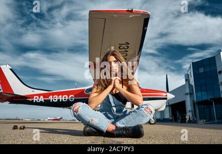 beautiful girl on the runway at the plane Stock Photo