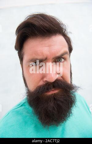 Strict face. Beard fashion barber. Handsome guy. Masculinity concept. Suspicious look. Man bearded hipster stylish beard grey background. Perceptions of male beauty. Stylish beard and mustache care. Stock Photo