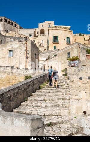 Tourists climbing steps leading to Baccanti Restaurant in Sassi District of Matera, Basilicata Region, Southern Italy Stock Photo