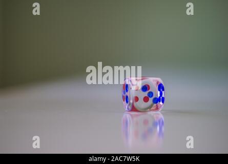 Translucent colored dice and reflection on white surface Stock Photo