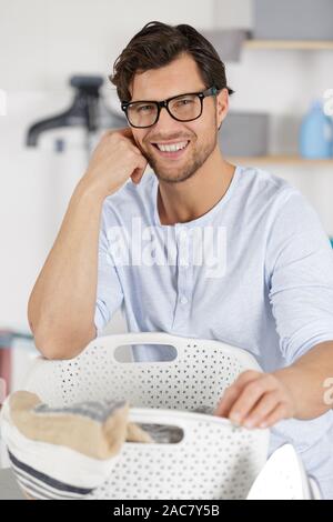happy man taking clothes from drying rack Stock Photo