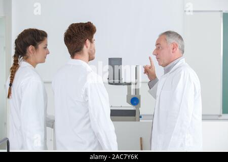 teacher pointing students attention towards projector screen Stock Photo