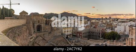 Aerial panoramic view of port city Cartagena in Spain with famous roman amphitheater. Beautiful sunset over the mountains. Wide angle lens panorama. Stock Photo