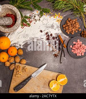 Delicious and beautiful handmade flat lay for christmas baking with chocolate chips, oranges, nuts, cinnamon cranberries vanilla and other decoration. Stock Photo
