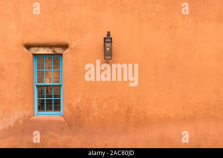 Old Southwestern Brown Adobe Wall with Window and Lantern Stock Photo