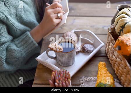 Autumn, pumpkins, hot steaming cup of coffee on a wooden table background. Seasonal, morning coffee, sunday relaxing and still life concept. Plans for the day Stock Photo