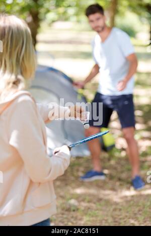 young couple playing badminton while on camping holiday Stock Photo