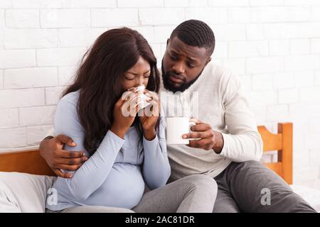 Handsome man taking care about his sick pregnant woman Stock Photo