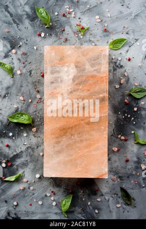 Himalayan pink salt block and crystals on gray concrete background top view copy space Stock Photo