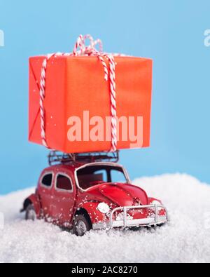 Retro car Volkswagen Beetle carrying red big box with Christmas presents Stock Photo