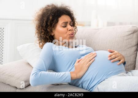 Expectant woman having contractions and doing breathing exercises Stock Photo