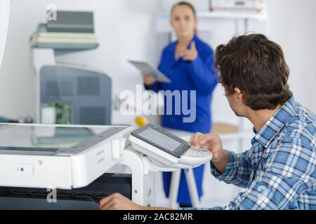 a technician fixing a printer Stock Photo