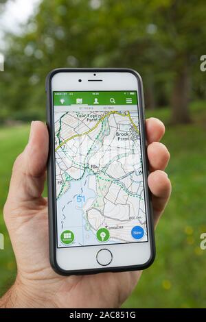 BATH, UK - SEPTEMBER 1, 2015 : Close-up of a male hand holding up a smartphone displaying an Ordnance Survey map in the ViewRanger application. Stock Photo