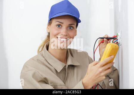 female electrician testing a wall socket Stock Photo