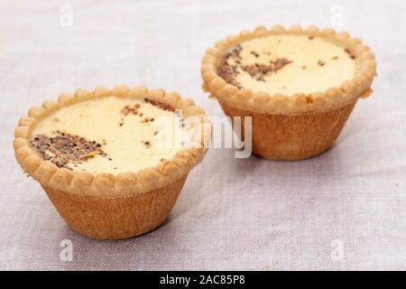 Two custard tarts on a linen cloth background Stock Photo