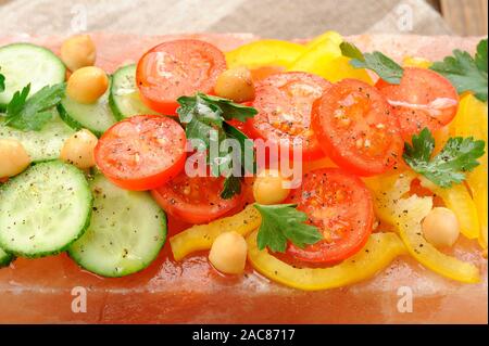 Vegetable salad on pink salt block closeup macro Stock Photo