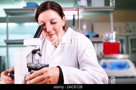 Scientist researching and evaluating with a microscope Stock Photo