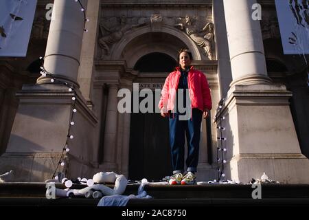 London, UK. 30th Nov, 2019. Artist Anne Hardy poses surrounded by her light-and-sound installation 'The Depth Of Darkness The Return Of The Light', which now covers the facade of the Tate Britain art gallery.Hardy's piece was unveiled as the gallery's 2019 Winter Commission, is intended to make the building resemble a 'marooned temple'. A thundery soundtrack accompanies the strings of light bulbs and other objects fixed to the steps and masonry of the front of the gallery. The installation will remain in place until January 26 the next year. (Credit Image: © David Cliff/SOPA Im Stock Photo