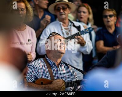 Close up of musician playing ukelele radiating joy outside a bar in Garachico, Tenerife, Spain on 23 November 2019 Stock Photo