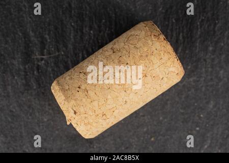 One whole common wine cork flatlay on grey stone Stock Photo