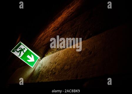 Emergency exit sign illuminated with dark background. Stock Photo