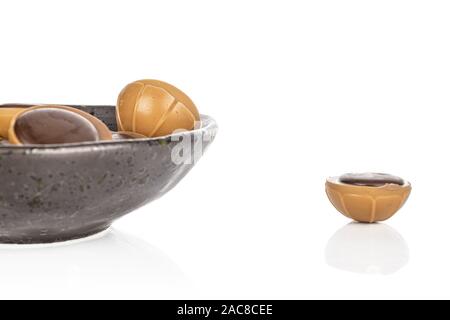 Lot of whole sweet brown toffee in glazed bowl isolated on white background Stock Photo