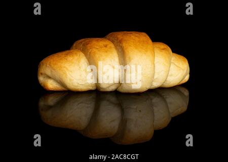 One whole sweet golden mini croissant isolated on black glass Stock Photo