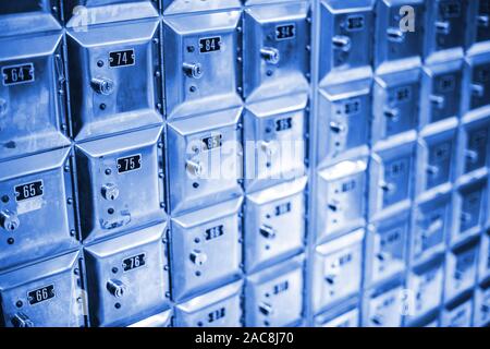 Multiple Spanish postal lock mail boxes with two and three digits number inside local postal office Stock Photo