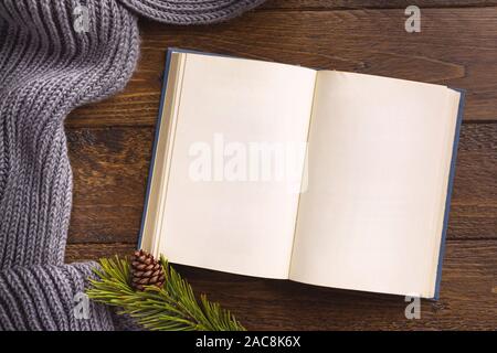 Open book and winter decor, on wooden background. Flat lay, top view, copy space. Stock Photo