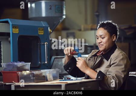 Portrait of smiling African-American woman working at production line at factory, copy space Stock Photo