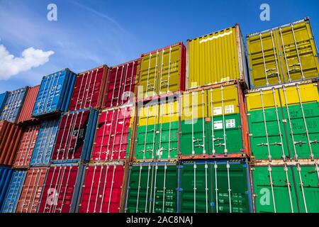 The national flag of Guinea Bissau on a large number of metal containers for storing goods stacked in rows on top of each other. Conception of storage Stock Photo