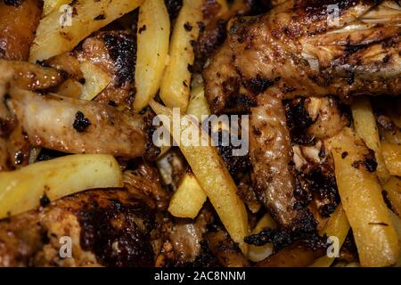 Chicken wings marinated with spices fried in a pan with potatoes. Home cooking. Stock Photo
