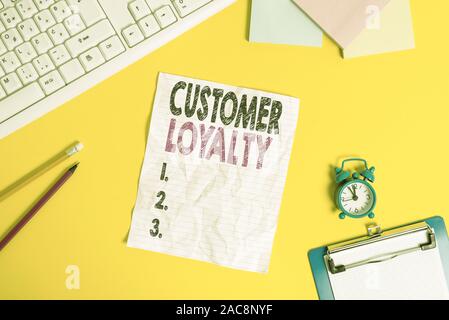 Text sign showing Customer Loyalty. Business photo text customers are devoted to a company s is products or services Copy space on notebook above yell Stock Photo