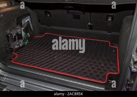 Clean black leather car floor mats with diamond  red stitching and gas pedals and brakes in the workshop for the detailing vehicle after dry cleaning Stock Photo