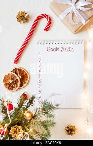 Notebook with wish list and christmas decorations on white table. Festive mood. Stock Photo