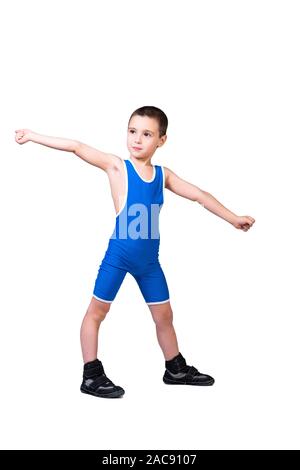 Little funny boy in a  blue sports tight holds hands to the side and smiles at his achievements on a white isolated background.  The concept of a litt Stock Photo