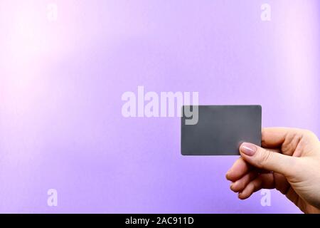 Demonstration of a gray card in a hand on a purple background. Stock Photo