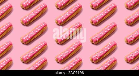 Seamless food creative texture or background. Eclairs pattern with pink icing and stars sprinkled on pink background. Stock Photo