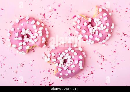 Creative layout made of pink bitten donuts with marshmallows. Food concept.