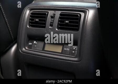 The rear central console on the panel inside the car close-up with climate control for heating or cooling passengers in gray and black. Auto service i Stock Photo