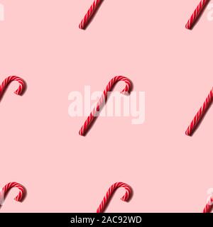 Seamless Christmas texture made of candy cane and shadow on pink background. Stock Photo