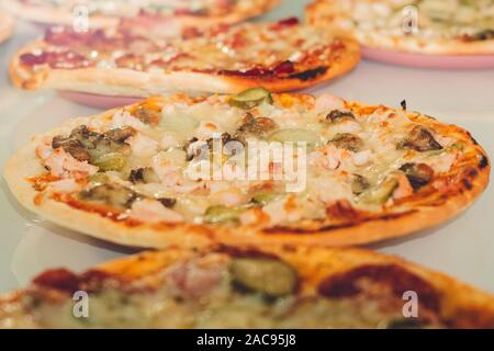 Pizza with Mozzarella cheese, sausage, mushrooms, Tomato sauce, Spices and pickled cucumbers. Stock Photo